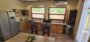a kitchen with a refrigerator and a table with a bowl of fruit at Villa Hunzibar Jambiani in Jambiani
