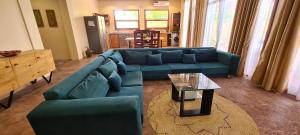 a living room with a blue couch and a table at Villa Hunzibar Jambiani in Jambiani