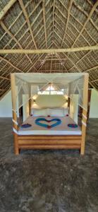 a bed with a canopy in a room at Villa Hunzibar Jambiani in Jambiani +21 photos
