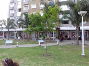 un parque con bancos y un árbol frente a un edificio en Departamento Temporario Villa Sol en Córdoba