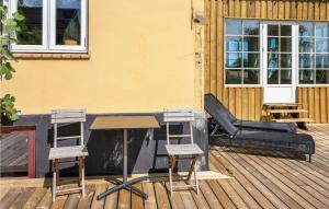 a table and two chairs on a wooden deck at 5 Bedroom Nice Home In Svaneke in Svaneke +28 photos