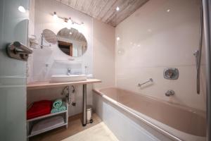 a bathroom with a tub and a sink and a bath tub at Hotel Landhaus Carla in Mayrhofen +46 photos