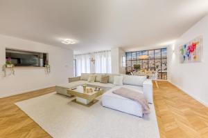 a living room with a white couch and a table at Villa Familiale Piscine Jaccuzi Entre Disney et Paris in Rosny-sous-Bois