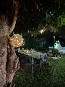 a table and chairs sitting under a tree at night at Bed & Breakfast Residenza Cuore in Udine +15 photos