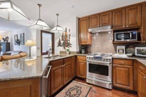 a kitchen with wooden cabinets and a stove top oven at Ascent 203 by East West Hospitality in Avon