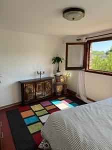 a bedroom with a bed and a window and a rug at Besalú Pont Vell Apartment in Besalú