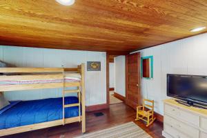 a bedroom with bunk beds and a flat screen tv at Captain's Corner in Manzanita