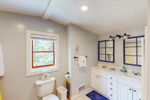 a bathroom with a toilet and a sink and a window at Captain's Corner in Manzanita +18 photos