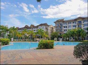 a resort with a large swimming pool and palm trees at Ecowest Condo beside SM Mall in Davao City
