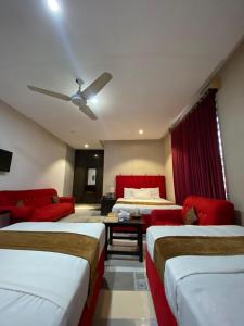 a hotel room with two beds and a couch at Hotel Tulip Inn, Gulberg in Lahore