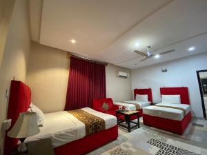 a hotel room with two beds and a couch at Hotel Tulip Inn, Gulberg in Lahore