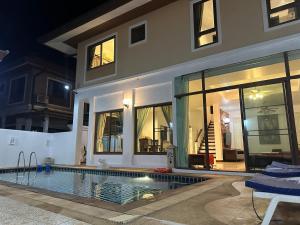 a house with a swimming pool at night at San pool villa in Patong Beach
