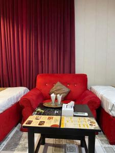 a living room with a red couch and a table at Hotel Tulip Inn, Gulberg in Lahore