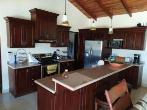 a kitchen with wooden cabinets and a counter top at Peaceful and Private Villa in Concepción
