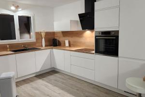 a white kitchen with white cabinets and a sink at Mini villa Favone in Conca