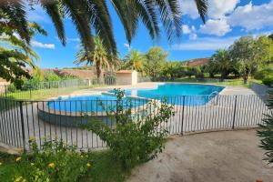 a fence around a swimming pool in a yard at Mini villa Favone in Conca