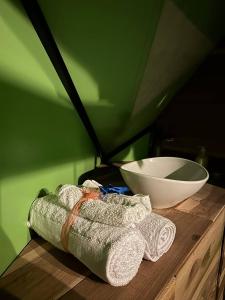 a towel and a bowl on a wooden table at Glamping Terranova Guatavita Colombia in Guasca +43 photos