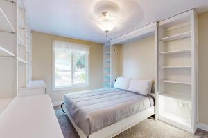 a bedroom with a bed and a window and shelves at Sea Breeze Escape in Warrenton