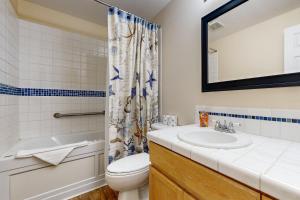a bathroom with a sink and a toilet and a shower at Sea Breeze Escape in Warrenton +16 photos