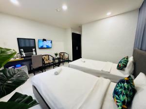 胡志明市Centana Ben Thanh Hotel的一间带两张床和电视的客厅 更多29张照片