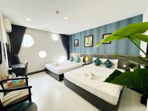 胡志明市Centana Ben Thanh Hotel的一间酒店房间，配有两张床和一张沙发