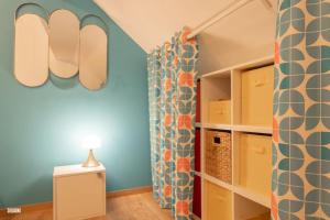 a room with a blue wall and a book shelf at Hypercentre, calme, vintage - Le Rétro in Pontarlier