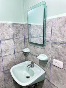 a bathroom with a sink and a mirror at Hermosa habitación en el corazón de Otavalo in Otavalo