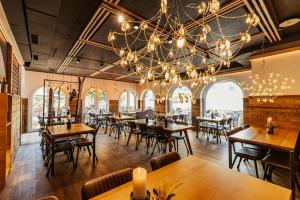 ein Restaurant mit Tischen und Stühlen und einem Kronleuchter in der Unterkunft Roggenstock Lodge in Oberiberg