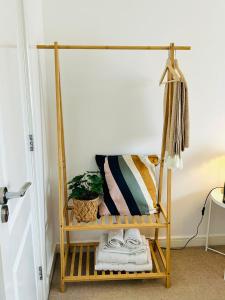 a shelf with towels and a plant on it at Cozy Glam Patchway Garden House Sleep 9 Mid-Long Term Welcome in Bristol