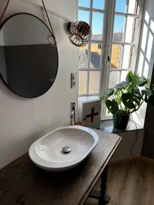 łazienka z umywalką i lustrem na stole w obiekcie La Casa Rosa w mieście Néant-sur-Yvel