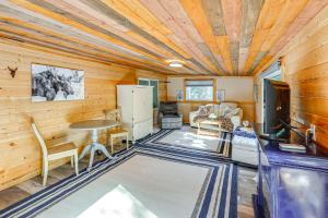 a living room with wooden walls and a wooden ceiling at Delta Junction Retreat with Northern Lights Cabin! in Delta Junction