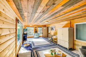 a living room with a tv and wooden walls at Delta Junction Retreat with Northern Lights Cabin! in Delta Junction