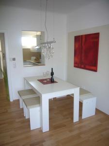 einen weißen Tisch und Bänke in einem Zimmer in der Unterkunft Apartment Mödling in Mödling