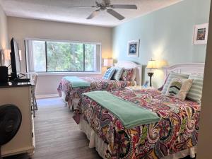 a bedroom with two beds and a window at Village House 102 in Hilton Head Island