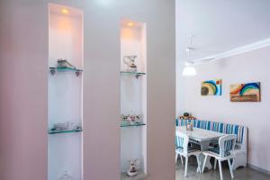 comedor con paredes blancas y mesa en Apartamento Águas de Lindoia, en Águas de Lindóia