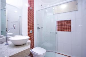 Un baño con inodoro y ducha de cristal. en Apartamento Águas de Lindoia, en Águas de Lindóia