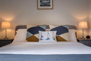 ein Bett mit zwei Lampen und zwei Kissen darauf in der Unterkunft Captain's Cottage - Central West Cowes - Spacious, entire 1-bed home in Cowes