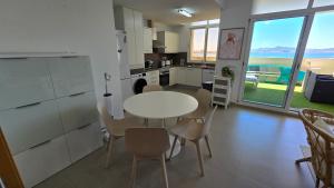 een keuken en eetkamer met een tafel en stoelen bij SolDosMares Apartmentos in La Manga del Mar Menor