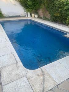 a blue swimming pool with a hose in it at Gold House in Neuquén