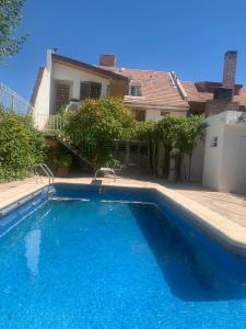 a large blue swimming pool in front of a house at Gold House in Neuquén
