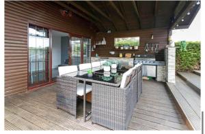 a patio with a table and chairs on a deck at Brig o Doon House Alloway in Ayr