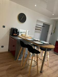 a kitchen with a table with chairs and a clock on the wall at Appartement la citadelle in Belfort +12 photos