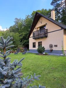 une maison avec un balcon sur le côté dans l'établissement Лесной Коттедж Нова, à Živohošť