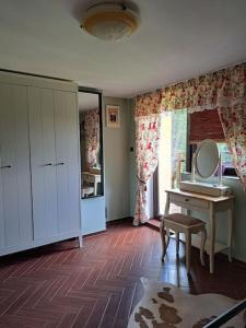 La salle de bains est pourvue d'une coiffeuse et d'un miroir sur une table. dans l'établissement Лесной Коттедж Нова, à Živohošť