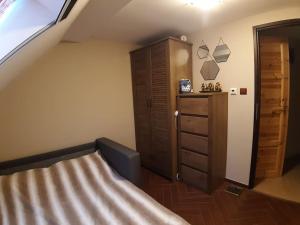 une chambre avec un lit et une commode en bois dans l'établissement Лесной Коттедж Нова, à Živohošť