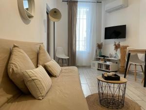 una sala de estar con un sofá y una mesa en Joli appartement hypercentre T2, classé meublé de tourisme 3 avec parking gratuit, en Béziers