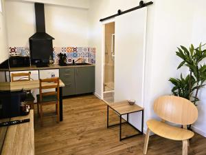 a kitchen with a table and a dining room at NERO studio Paris Villejuif CLIM confort tt équipé! Métro 7 et 14 in Villejuif