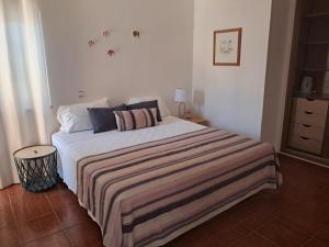 a bedroom with a bed with a striped blanket on it at Dona Ana Guesthouse in Lagos +12 photos