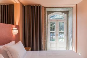 un dormitorio con una cama y una ventana en Hotel Margarida Da Praça, en Viana do Castelo