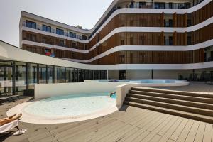 a building with a swimming pool in front of a building at Resort Baltic Waves Apartments - Basen, Sauna in Międzyzdroje